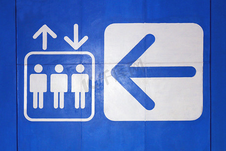 电梯图标标志白色箭头符号电梯在蓝色背景上，电梯符号概念警告信息标志平面样式在混凝土墙上蓝色