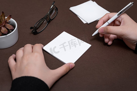 女人手拿着空白笔记写新的 Messege 更新想法。 
