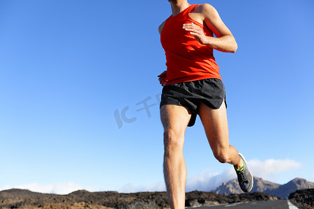越野跑步摄影照片_跑步者特写 — 在路上跑步的男运动员