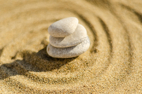 沙中的禅修石、纯洁和谐与灵性的概念、水疗健康和瑜伽背景