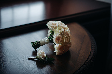 胸花新娘摄影照片_带玫瑰和胸花的婚礼花束。婚礼上的装饰