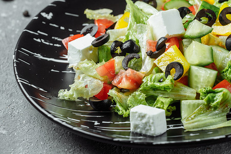 希腊沙拉配黄瓜、卡拉马塔橄榄、羊乳酪、多汁的樱桃番茄和新鲜罗勒。