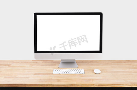 木桌和白墙背景上的样机空白屏幕台式电脑。
