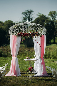 婚礼在绿色草坪的街道上举行。仪式用鲜花拱门装饰