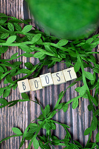 Boost text wooden cubes immune system text with wood cubes and fresh organic leafs on background with wood texture, Boost for Healht 概念