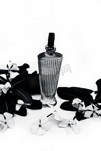 关闭年度长春花或马达加斯加长春花或萨达巴哈或萨达巴哈的香水或喷雾在透明玻璃瓶中，原花隔离在白色。