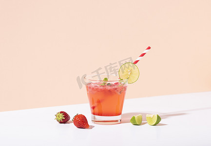 冰镇草莓潘趣鸡尾酒在玻璃杯中加柠檬，颜色背景。