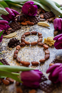 庆典月摄影照片_3 月 8 日，国际妇女节，八颗来自可可豆、紫色郁金香和手工巧克力