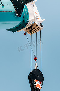 玻璃现代建筑附近带吊钩的蓝色起重机升降机构、起重机和液压升降机高达 120 米