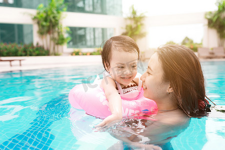 妈妈和小女孩在泳池里玩得很开心。