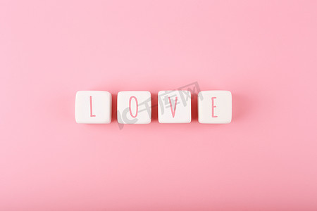 简单方块背景摄影照片_粉红色背景下白色玩具方块上写的爱字，有复制空间