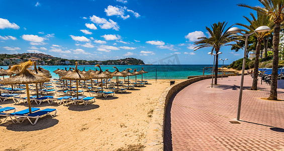 沙滩躺椅伞摄影照片_沙滩在圣庞萨，马略卡岛，西班牙地中海，巴利阿里群岛