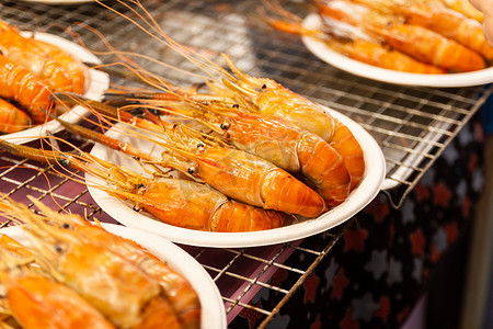 古代食品摄影照片_泰国曼谷市场餐桌上的泰国海鲜街头食品烤虾
