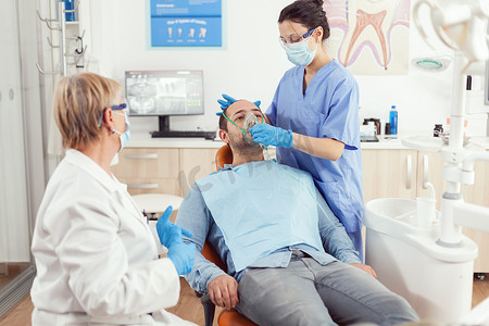 口腔科医生护士在牙齿手术前放上氧气面罩