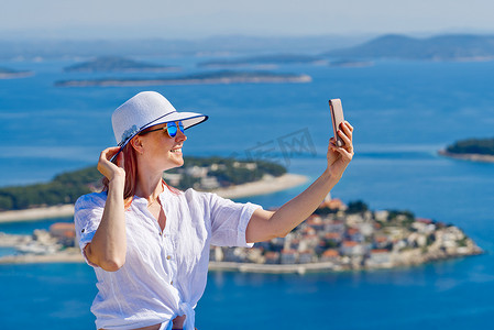 美丽的蓝色亚得里亚海和舒适的岛屿背景克罗地亚，戴着白色草帽的旅游女性