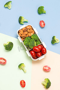 午餐盒摄影照片_夏季健康食品概念：带午餐盒的框架和蓝色背景的水果混合；