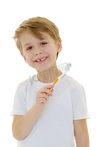 刷牙的小男孩摄影照片_一个小男孩正在用牙刷刷牙。