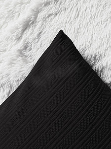 白色蓬松格子毯上的黑色垫枕作为平躺背景、卧室顶视图和家居装饰