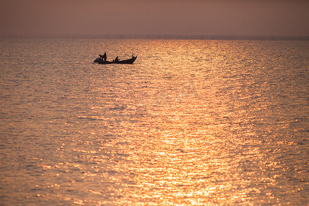 日落时分，小船漂浮在色彩缤纷的天空下