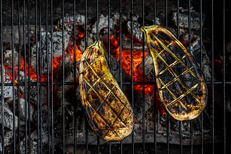 户外烧烤架摄影照片_烧烤茄子，户外烧烤架用火。
