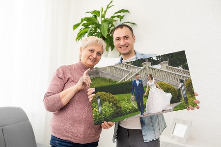 一个男人和一个女人拿着一张照片画布。