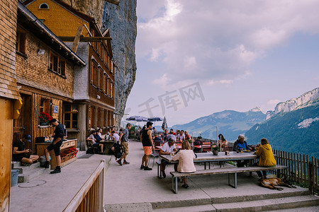 房屋山摄影照片_瑞士阿尔卑斯山和 Aescher 悬崖下的山间餐厅，从瑞士阿彭策尔地区的 Ebenalp 山望去 Aescher 悬崖