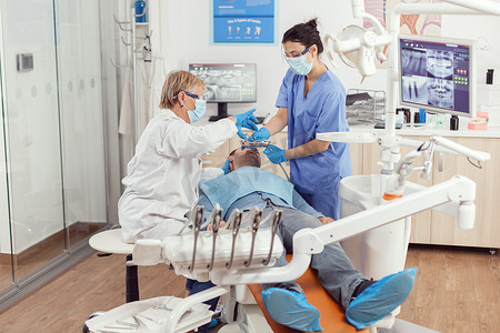 为病人进行专业牙齿清洁的牙医和医疗护士