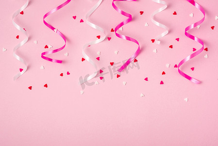 精致的粉红色派对背景，带彩带，用散落的五彩纸屑庆祝