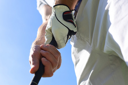 握球手摄影照片_高尔夫球手穿着高尔夫球手握推杆。