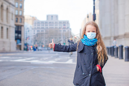 年轻女子戴着口罩在空荡荡的纽约行走，以抵御病毒