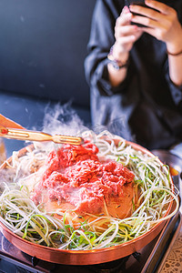 首尔韩国餐厅的牛肉烧烤烤肉，铜锅上的生活方式新鲜韩国美食，带切片烤架，特写，复制空间