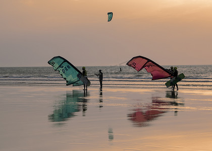 太阳落山时，风筝冲浪者从海上归来