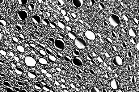 白色发光体摄影照片_黑色和白色的油滴在水面上。