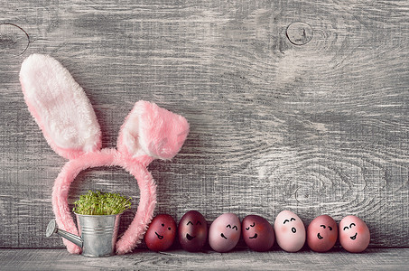 矢量兔子摄影照片_灰色木质背景上时尚色彩的复活节彩蛋，带复活节兔子耳朵的母环
