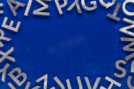 框架模型由蓝色背景上的银色金属英文字母字符制成。