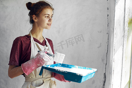 手拿刷子在家庭室内装修中油漆的女人
