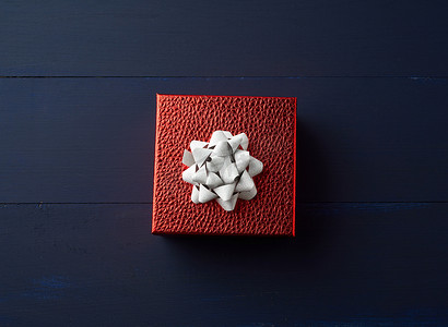 黑暗系摄影照片_方形红盒系着金丝带，祝贺的概念