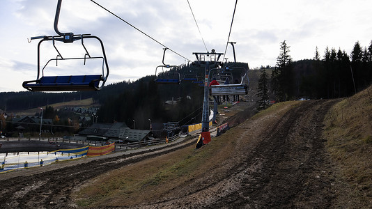 乌克兰，Bukovel - 2019 年 11 月 20 日。在秋季山坡和冬季滑雪胜地建设中的基础设施背景下，带缆车的滑雪胜地的秋季景色。
