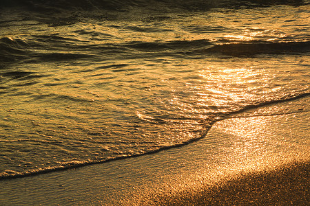日落时海滩上的波浪和沙子质地