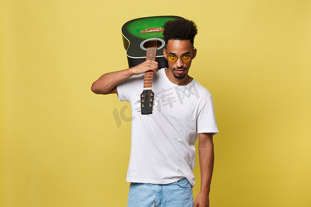 音乐家合影摄影照片_快乐的非洲裔美国音乐家在金黄色背景下用吉他合影。
