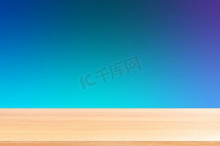 渐变蓝色软背景上的空木桌地板、木桌板空前彩色渐变、深蓝色渐变上的木板空白用于展示产品或横幅广告