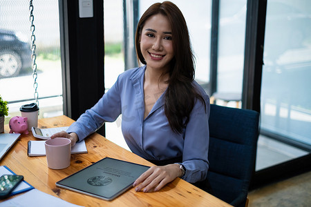 星巴克摄影照片_泰国清迈 — 2021年8月23日：坐在星巴克咖啡店的女人和平板电脑上的星巴克标志