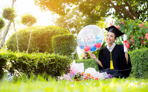 气球大学毕业摄影照片_快乐的毕业女学生-祝贺教育成功