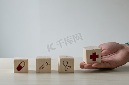 钱和医疗摄影照片_桌子上的木制立方体医疗保健和医疗图标。