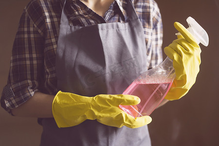 消毒水主图摄影照片_一个戴黄色橡胶手套的女人做家务