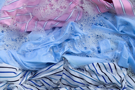 洗衣粉摄影照片_彩色衣物浸泡在洗衣粉水中溶解。