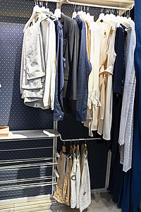 现代蓝色衣柜里的衣架上挂着许多不同的衣服。