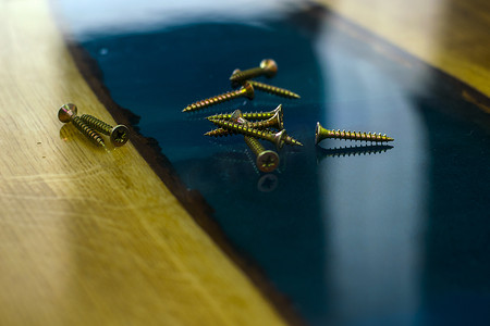 桌子上的金色螺丝由木头和环氧树脂特写制成
