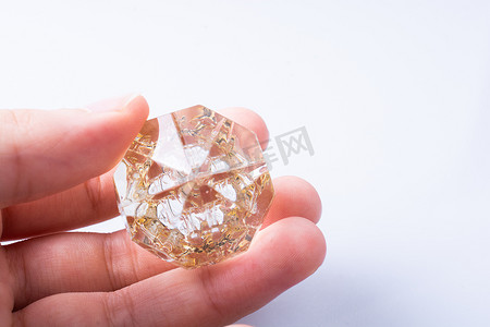 价格透明摄影照片_手拿着白色背景上的透明钻石