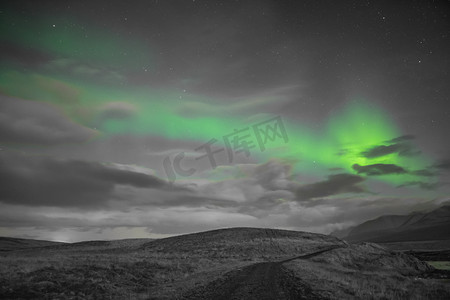 黑白月亮摄影照片_冰岛北极光的北极光明亮的光束在黑白风景中升起绿色